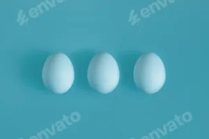 Three White chicken eggs on a blue background in the center.