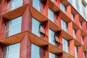 Modern office building exterior with glass facade on clear sky background. Transparent glass wall of