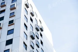 Modern white building with square windows. Multistory apartment building. Minimalistic Stylish