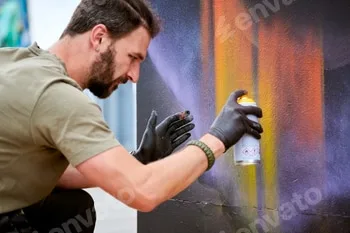 Attractive male artist is painting picture with paint spray can spraying it onto canvas 5 Attractive male artist is painting picture with paint spray can spraying it onto canvas