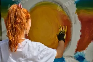 Young woman creating vibrant sun painting in outdoor setting