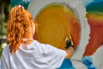 Young woman creating vibrant sun painting in outdoor setting