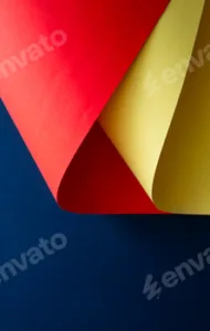 Vibrant red and yellow paper shapes contrasted against a blue background.