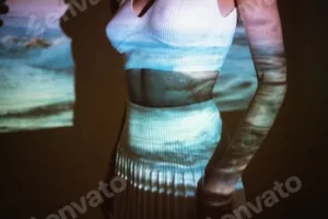 Young adult woman 20 years old with projected image of ocean or see in neon colors