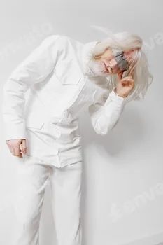 Fashion model with long white hair in a futuristic outfit posing against a minimalistic white