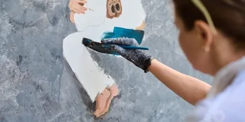 Female artist painting human figure on textured wall 42 Female artist painting human figure on textured wall