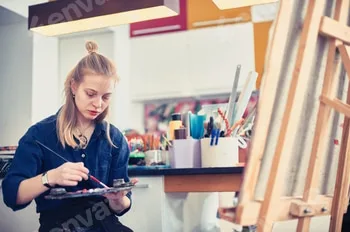 Young woman painting on canvas in a bright studio filled with art supplies at midday 3 Young woman painting on canvas in a bright studio filled with art supplies at midday